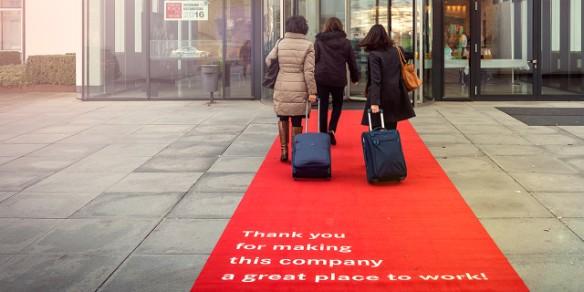 Frauen mit Reisekoffer auf rotem Teppich